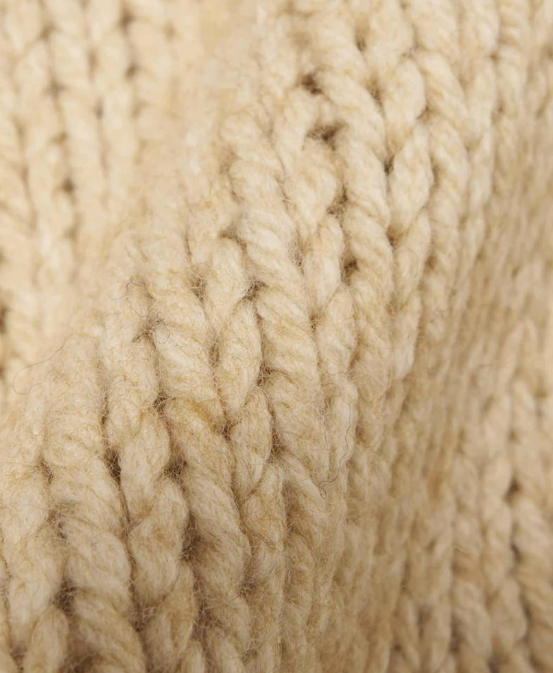 Close up of beige chunky knit wool fabric.