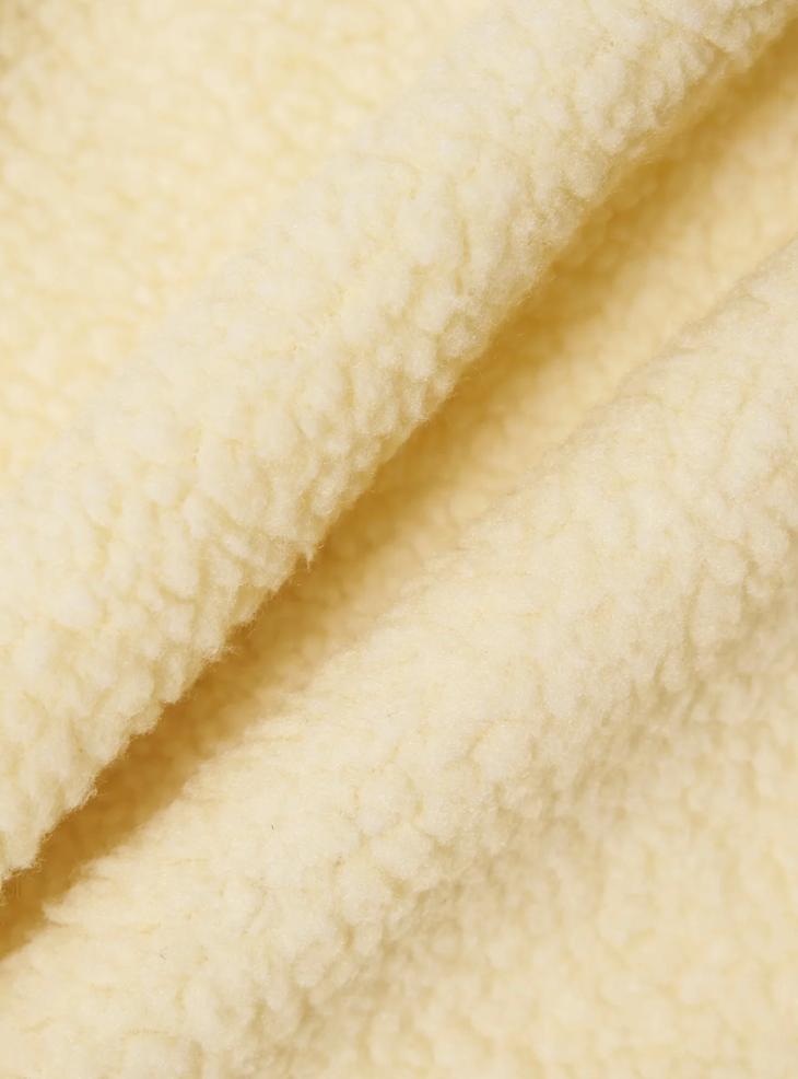 Close-up of ecru fleece fabric with a soft texture.