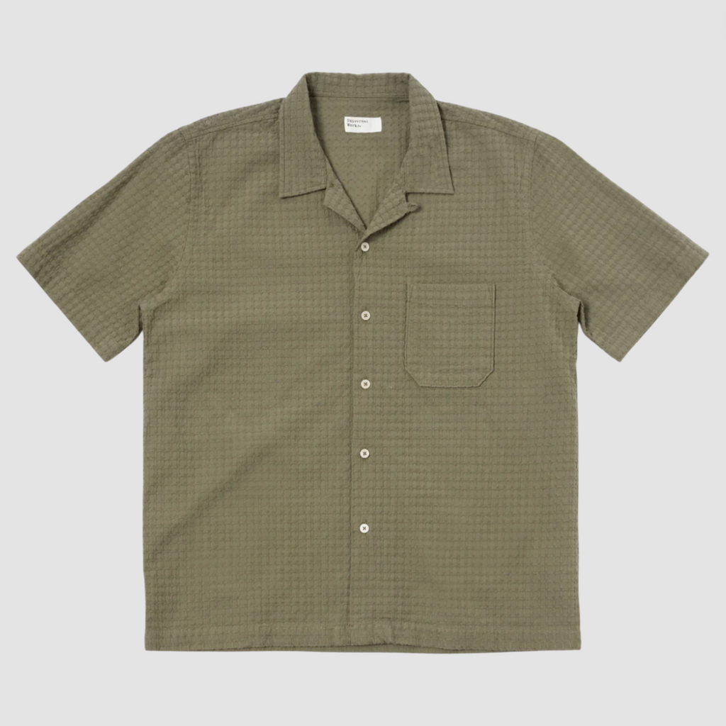 Olive short-sleeve cotton shirt with a regular fit, loop-close collar, straight hem, and a single chest patch pocket.