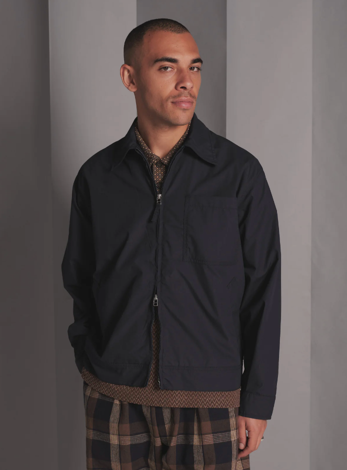 Navy boxy-fit jacket with an oversized collar, zip front, large patch pocket, welt pockets, pleated details, and an adjustable back hem.