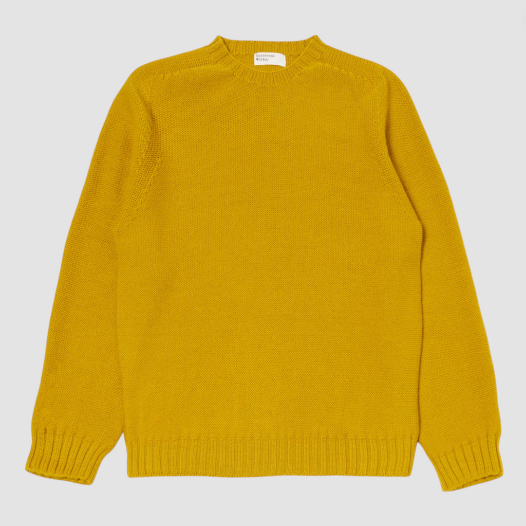Yellow wool sweater on a grey background.