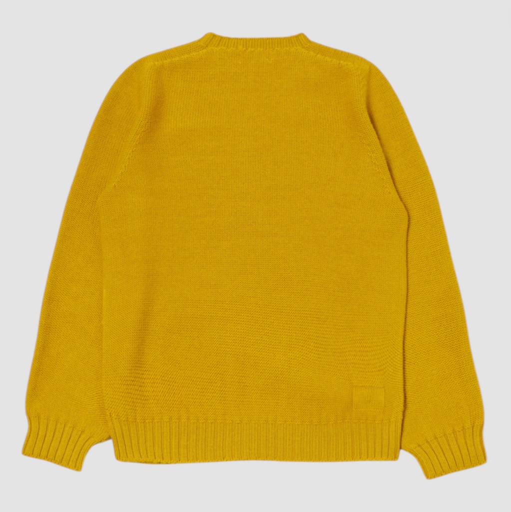 Yellow wool sweater on a grey background.