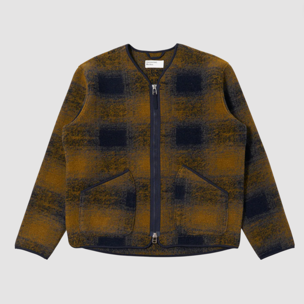 Navy and yellow checkered pattern wool fleece zip up cardigan on a grey background.