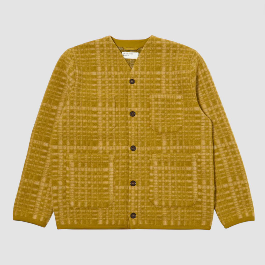 Yellow plaid shirt with black buttons on a light gray background.