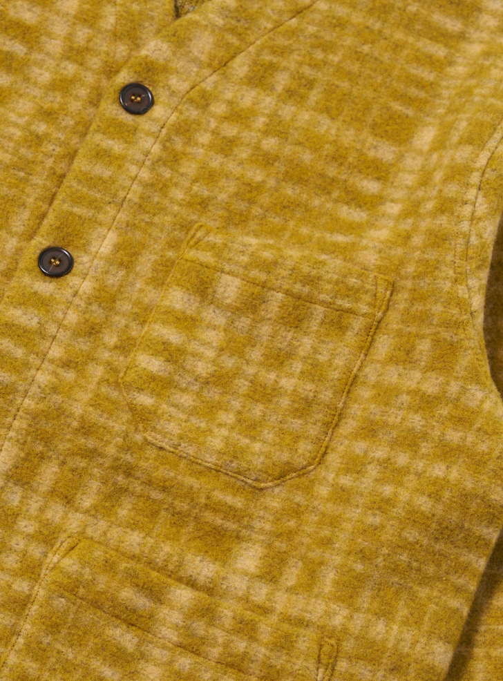 Close-up of a mustard yellow jacket with button details.