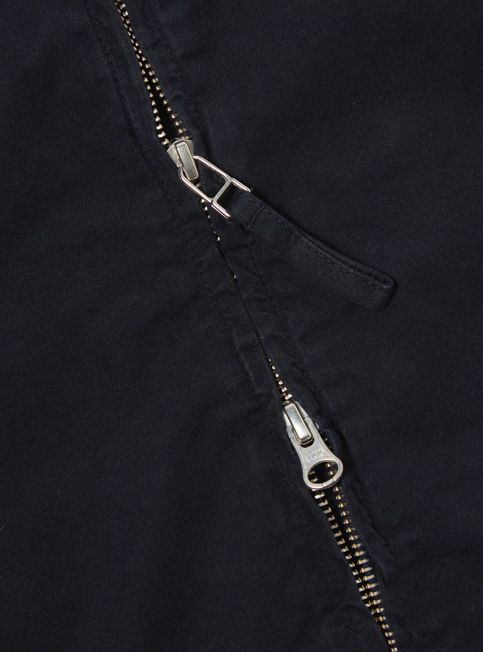 Navy cotton jacket with a double zip front, welt pockets, subtle arm stripe detail, and adjustable cuffs and waist tabs.