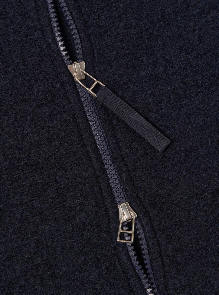 Close-up of a zipper on a dark fabric background.