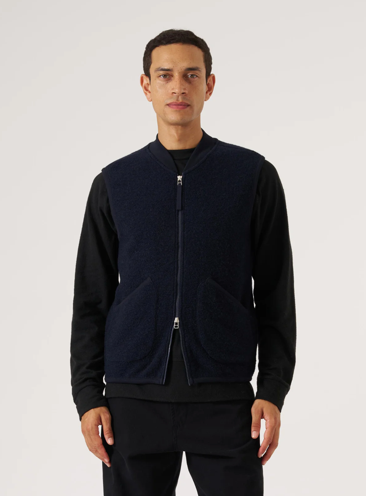 Man in navy fleece vest with zipper. 