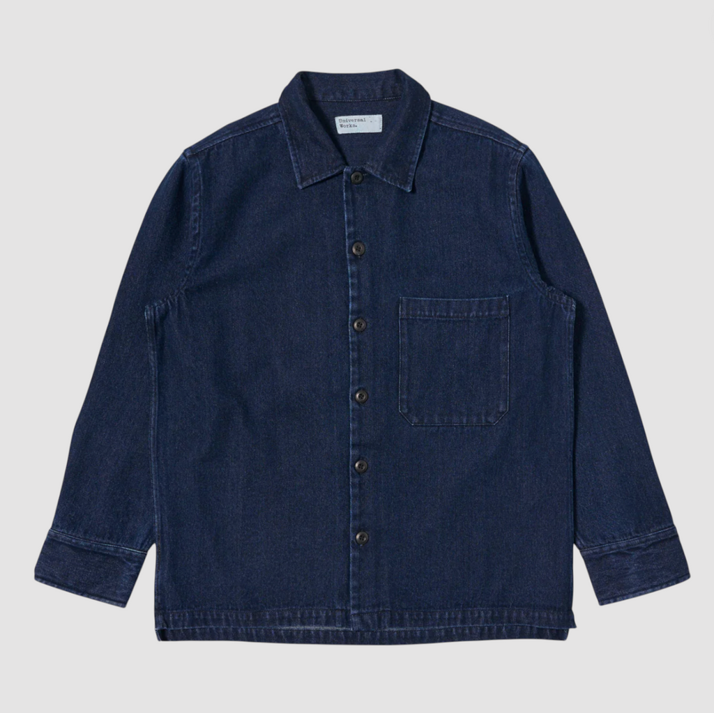 Blue denim shirt with a collar and pocket on a light gray background.
