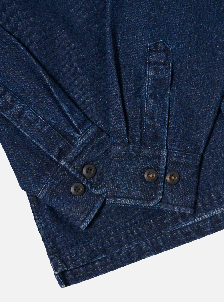 Close-up of a blue denim jacket with button details on a white background.