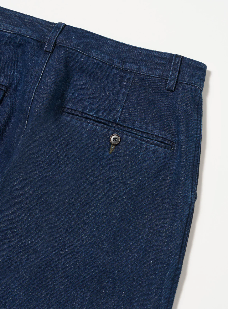 Close-up of blue pants with a button on a white background.
